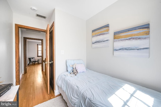 bedroom featuring light wood-style floors and visible vents