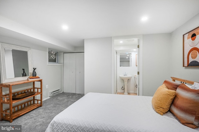 carpeted bedroom with a closet, recessed lighting, connected bathroom, and a baseboard heating unit