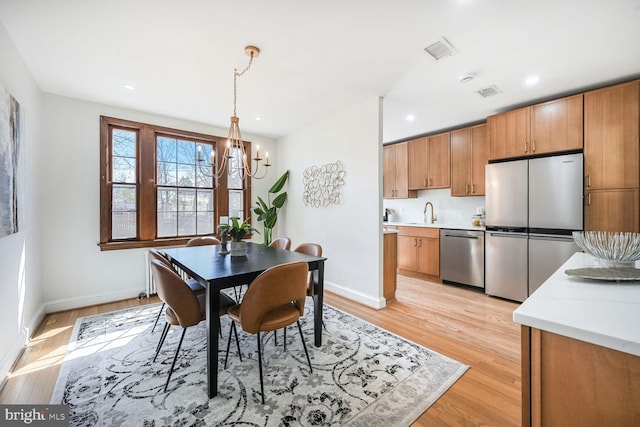 dining area featuring visible vents, baseboards, recessed lighting, a notable chandelier, and light wood-type flooring