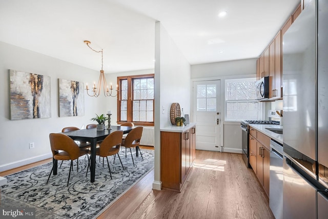 dining room with an inviting chandelier, light wood-style flooring, recessed lighting, and baseboards