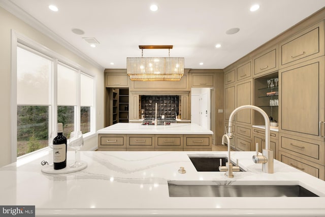 kitchen featuring crown molding, an island with sink, and pendant lighting