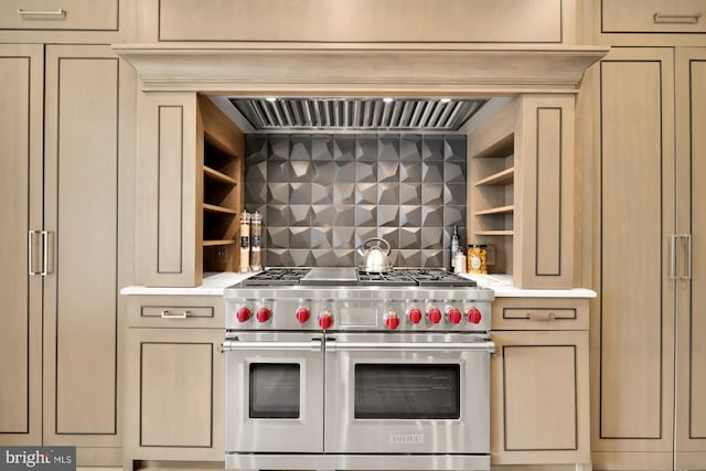 kitchen with cream cabinetry, decorative backsplash, double oven range, and premium range hood