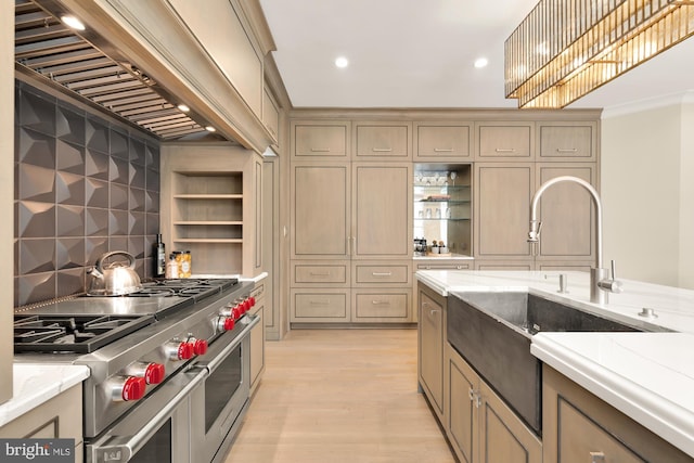 kitchen with custom exhaust hood, crown molding, sink, double oven range, and light hardwood / wood-style floors