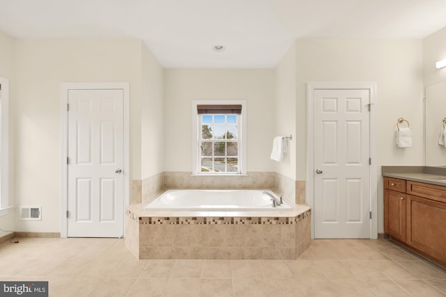 bathroom with vanity, tiled bath, and tile patterned floors