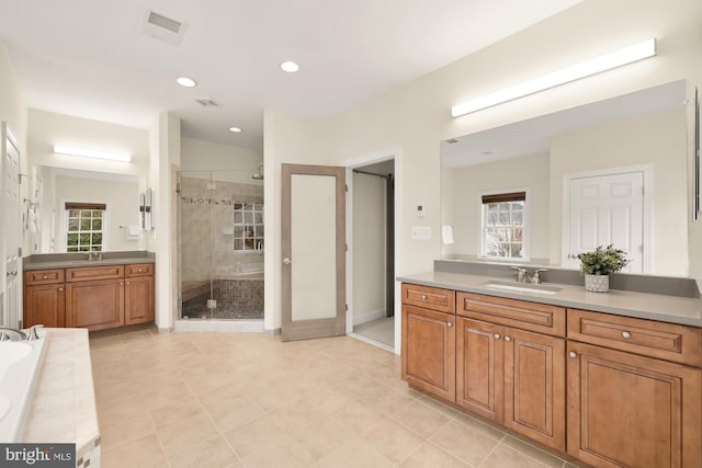 bathroom featuring tile patterned floors, vanity, and shower with separate bathtub