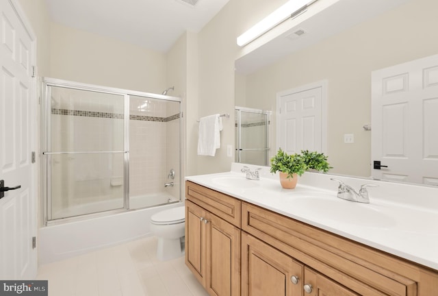 full bathroom with shower / bath combination with glass door, vanity, and toilet