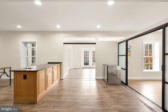 kitchen with hardwood / wood-style flooring, dark stone countertops, and french doors