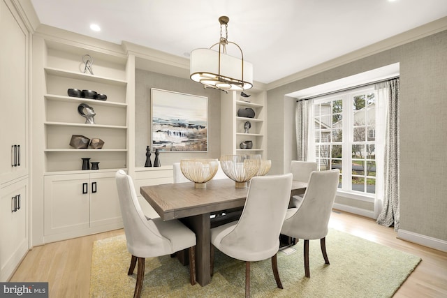 dining space featuring a notable chandelier, plenty of natural light, built in features, and light hardwood / wood-style flooring