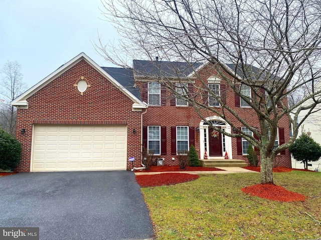 colonial house with a garage and a front lawn