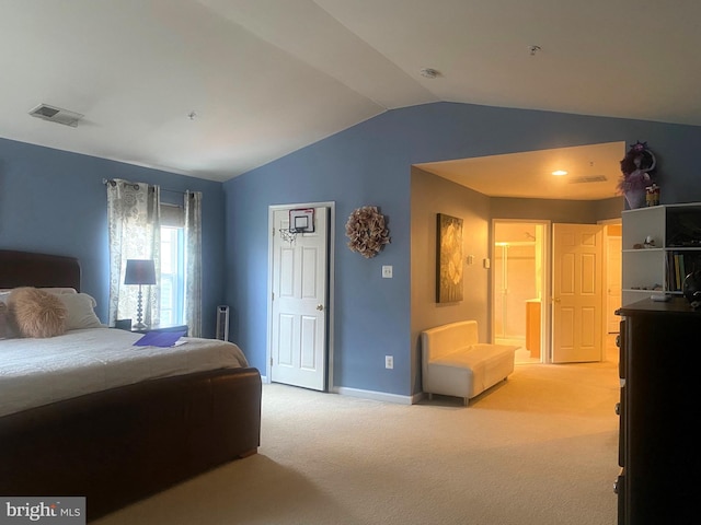 carpeted bedroom with ensuite bathroom and vaulted ceiling