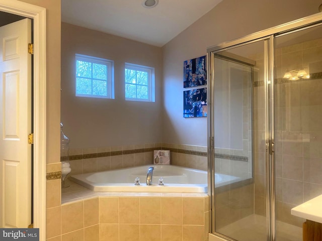 bathroom with lofted ceiling and shower with separate bathtub