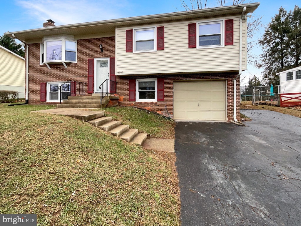 bi-level home with a front yard and a garage