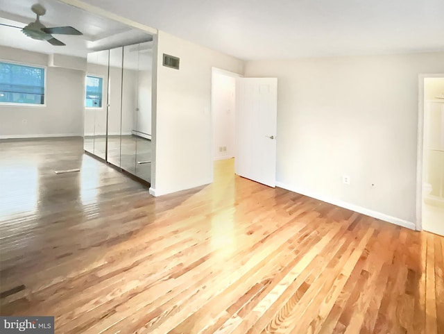 spare room featuring wood-type flooring, baseboard heating, and ceiling fan