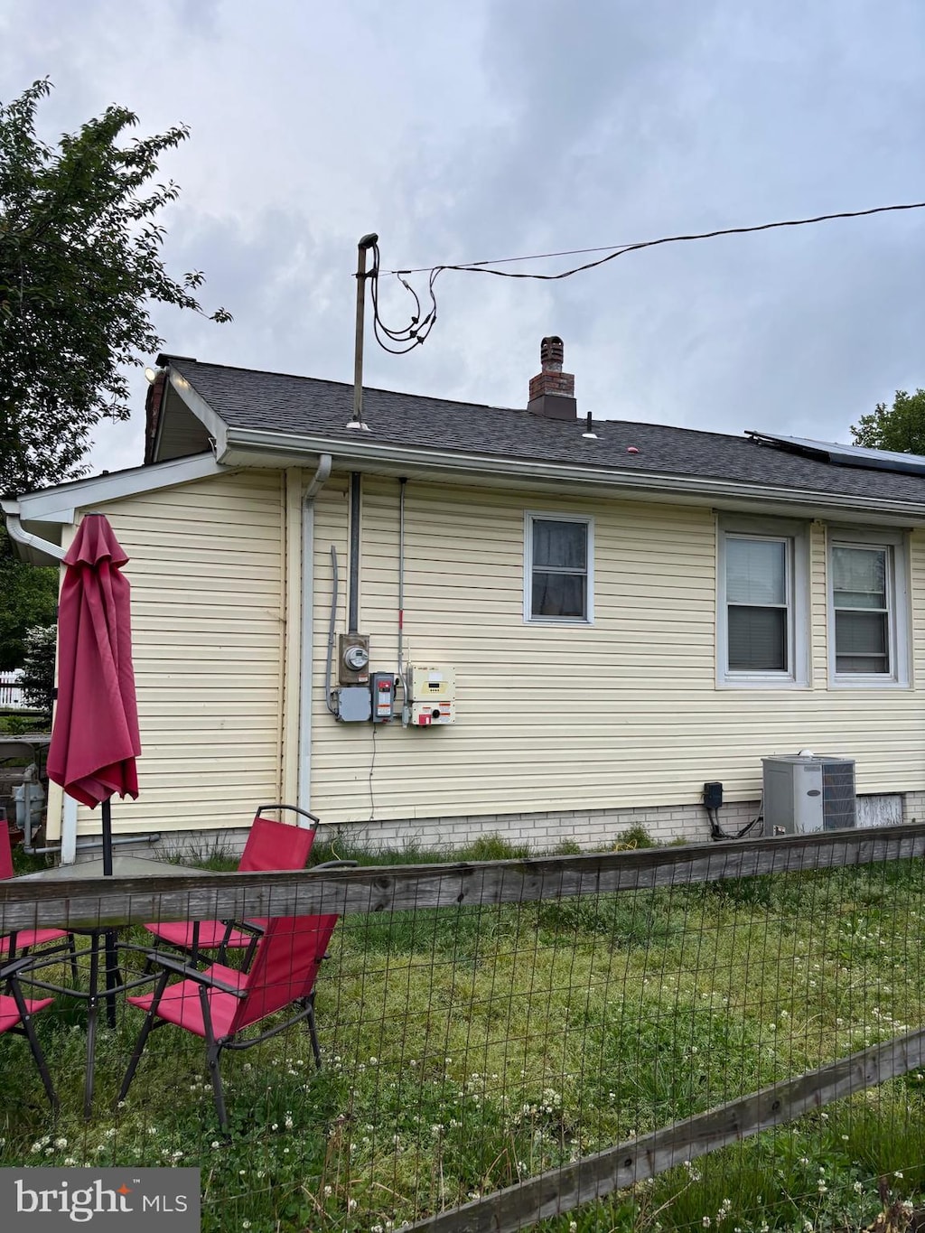 view of side of home featuring a lawn and cooling unit