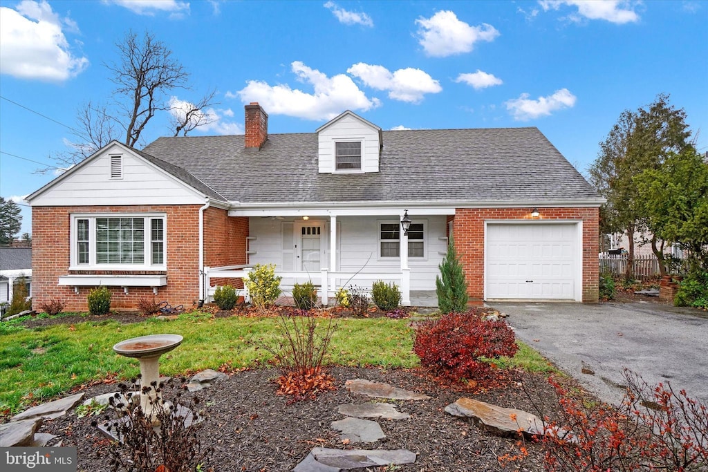 view of front of house with a porch, a garage, and a front yard