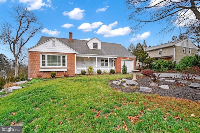 view of front of property featuring a front lawn, a porch, and a garage