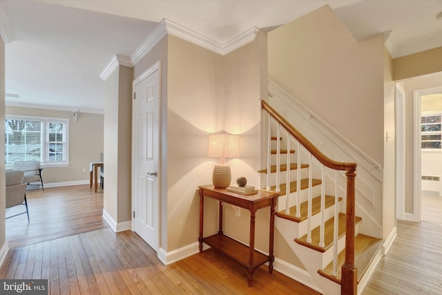 stairway featuring wood-type flooring and crown molding