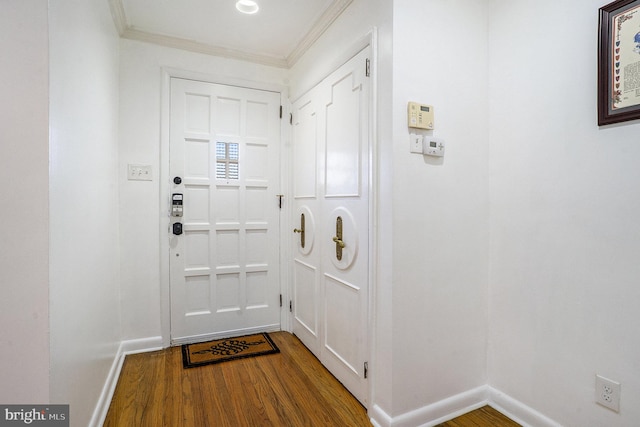 entryway with ornamental molding and hardwood / wood-style flooring