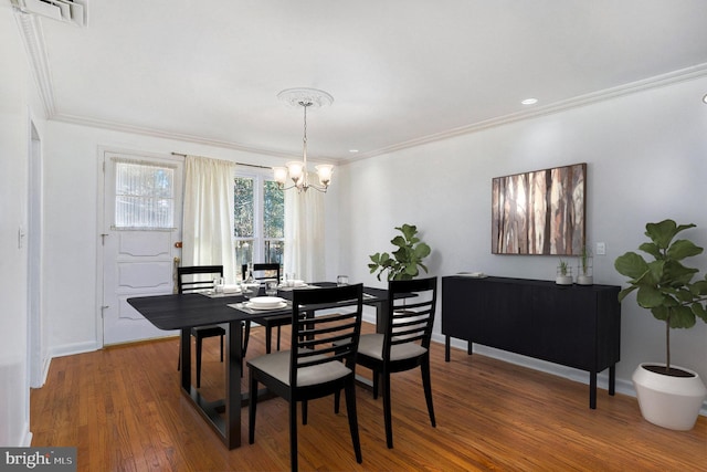 dining room featuring a notable chandelier, wood-type flooring, and ornamental molding