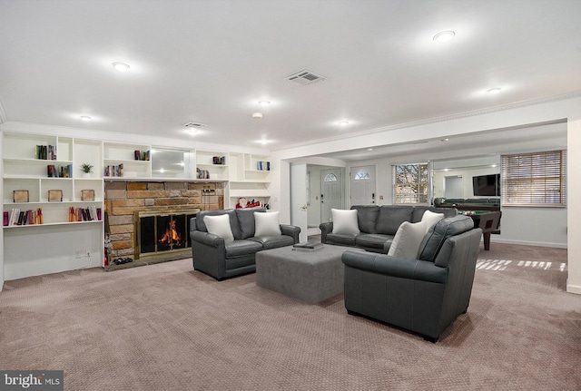 living room featuring built in shelves, a fireplace, light colored carpet, and ornamental molding