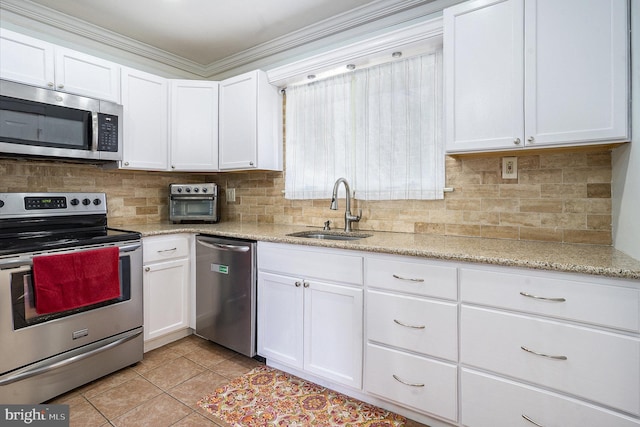 kitchen featuring appliances with stainless steel finishes, white cabinetry, ornamental molding, and sink