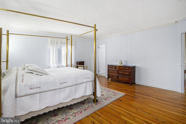 bedroom featuring wood-type flooring and ornamental molding