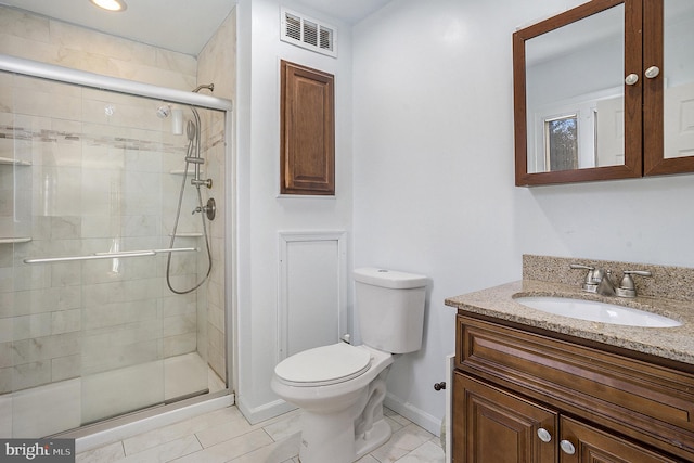 bathroom featuring tile patterned floors, vanity, a shower with shower door, and toilet