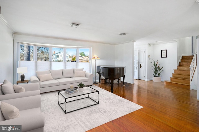 living room with crown molding and hardwood / wood-style floors