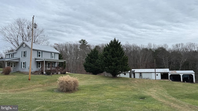 view of yard with a porch and an outdoor structure