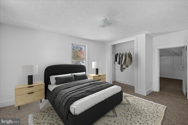 carpeted bedroom with a textured ceiling and a closet