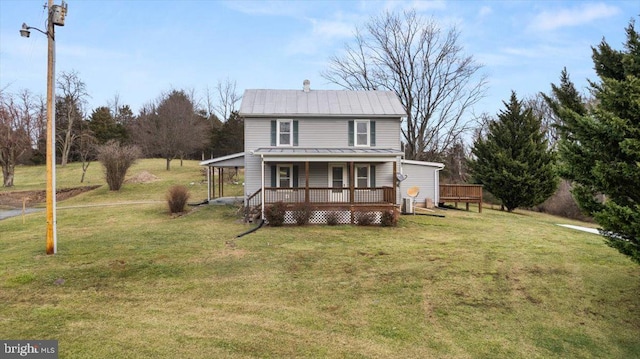 rear view of house featuring a porch and a yard