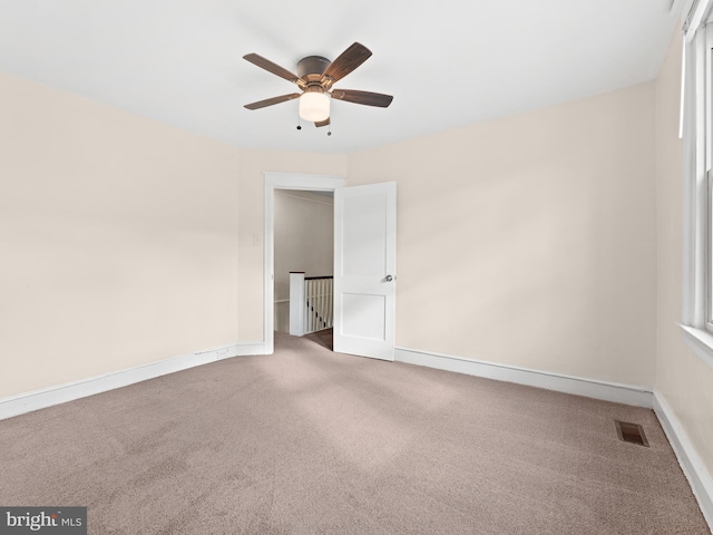 carpeted spare room with ceiling fan