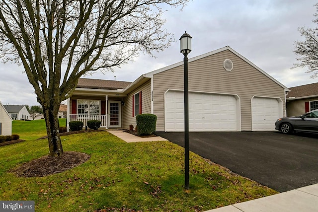 ranch-style home with covered porch, a garage, and a front yard