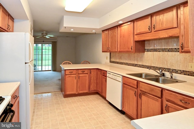 kitchen featuring kitchen peninsula, tasteful backsplash, white appliances, ceiling fan, and sink