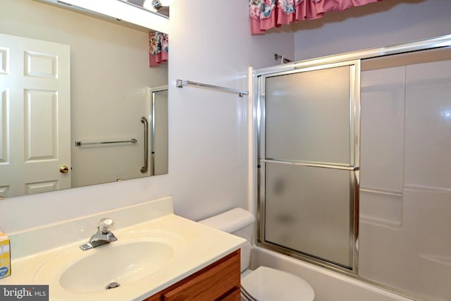 full bathroom with shower / bath combination with glass door, vanity, and toilet