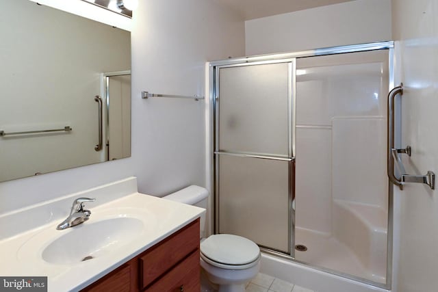 bathroom with tile patterned floors, vanity, toilet, and a shower with shower door