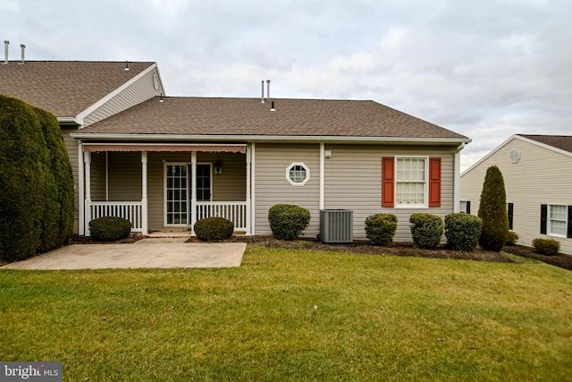 rear view of property with central AC unit, a patio area, and a yard