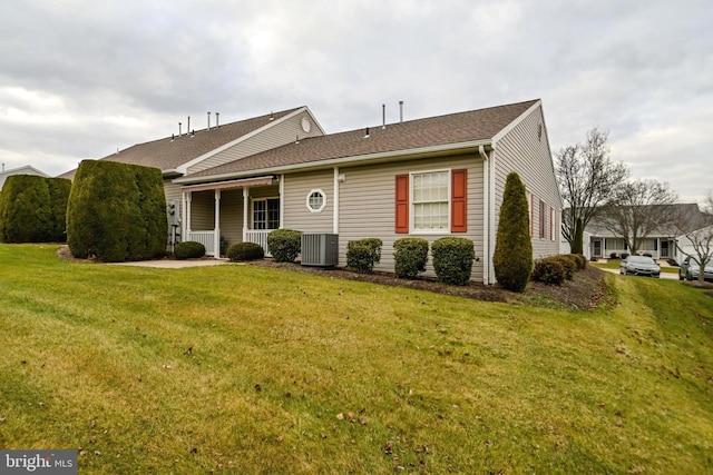 ranch-style house featuring central air condition unit and a front yard