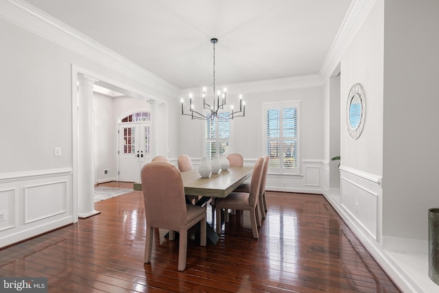 dining room featuring ornamental molding, dark wood-type flooring, and an inviting chandelier