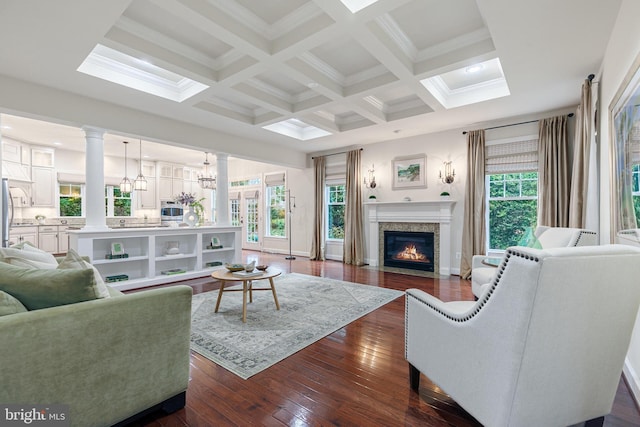 living room with beam ceiling, dark wood-type flooring, a wealth of natural light, and coffered ceiling