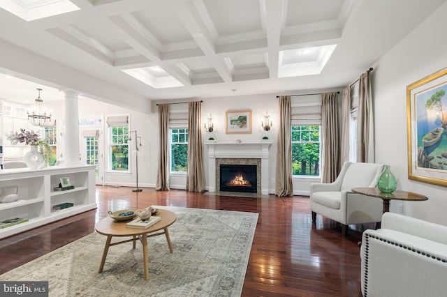 living room with coffered ceiling, ornamental molding, a notable chandelier, beam ceiling, and dark hardwood / wood-style flooring