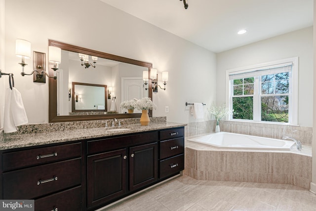 bathroom featuring tile patterned flooring, vanity, and a relaxing tiled tub