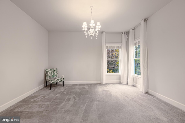 unfurnished room with carpet floors and a chandelier