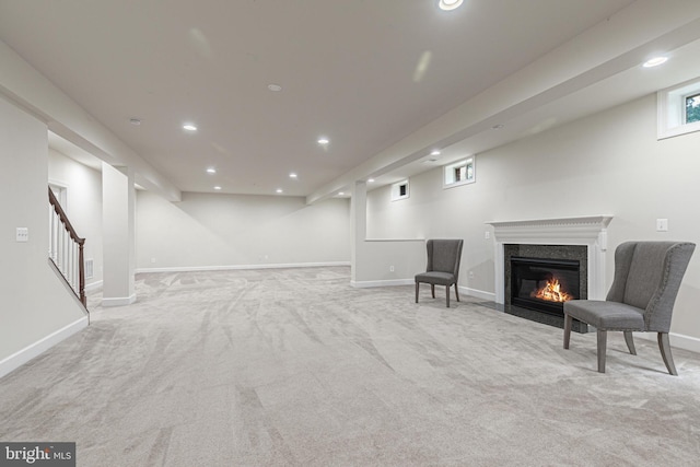 living area featuring light carpet and a high end fireplace