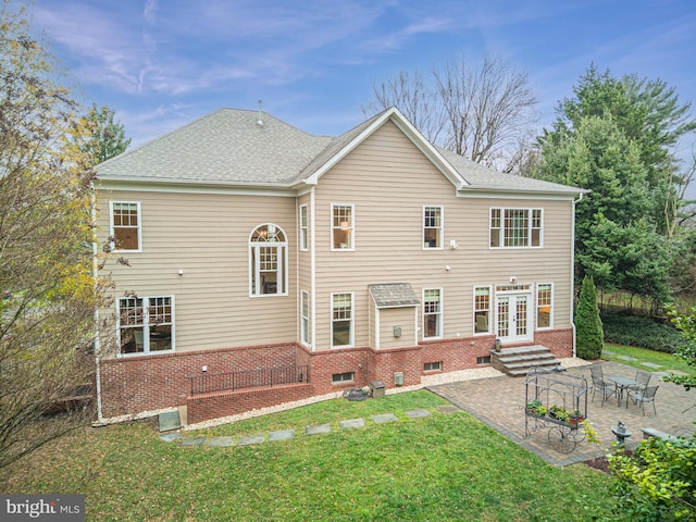 rear view of property featuring a yard, a patio area, and french doors