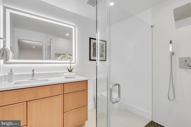 bathroom featuring a shower with shower door, vanity, and toilet