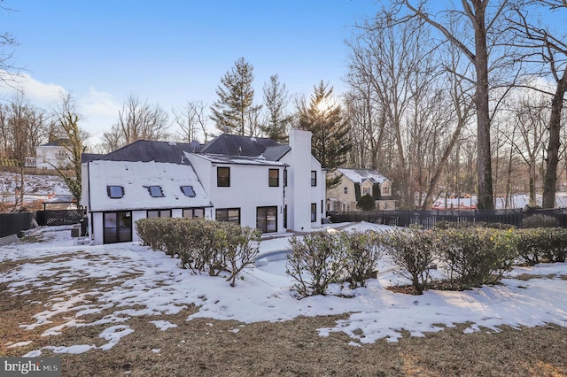 view of snow covered rear of property