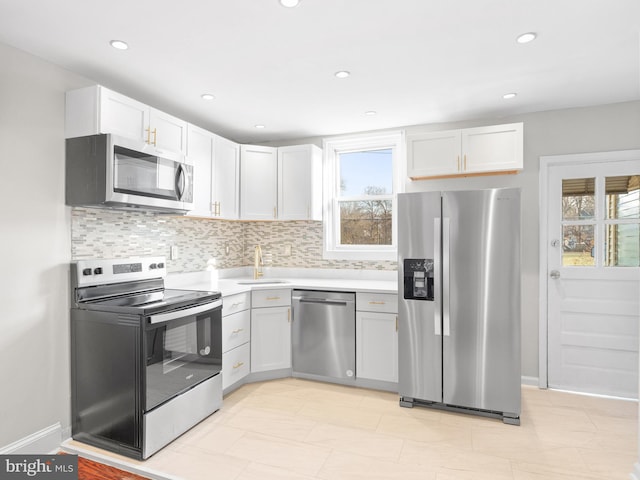 kitchen featuring white cabinets, appliances with stainless steel finishes, tasteful backsplash, and sink