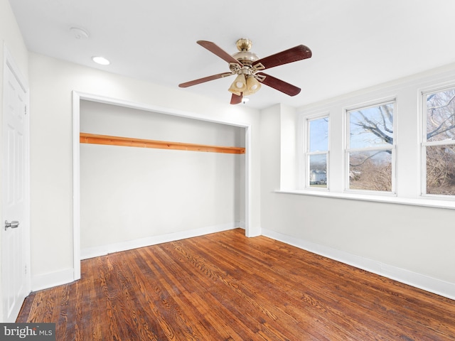 unfurnished bedroom with dark hardwood / wood-style flooring and ceiling fan