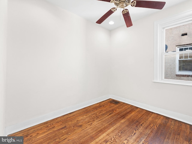 empty room with hardwood / wood-style floors and ceiling fan